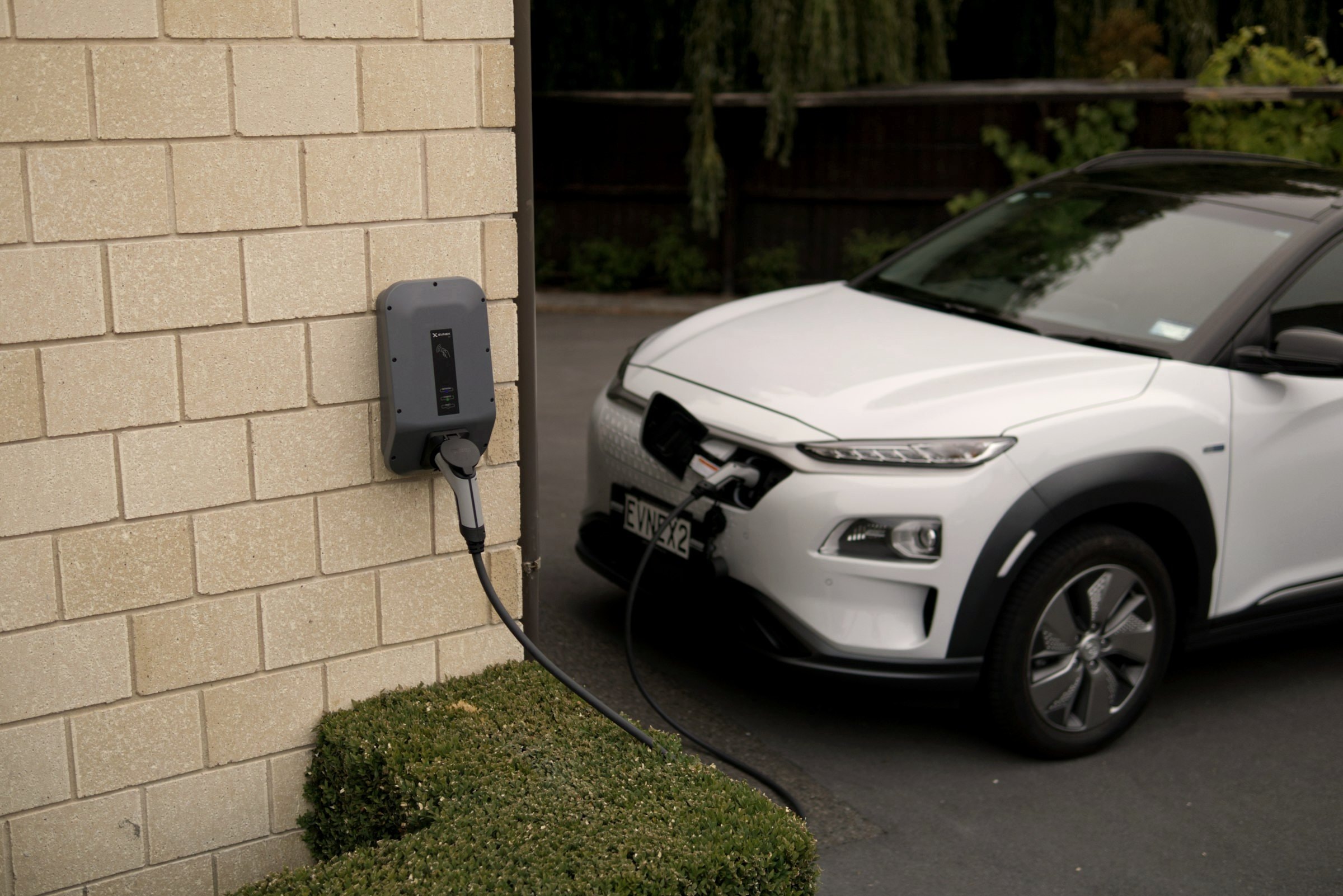 Elektroauto lädt an einer Wallbox an der Hauswand