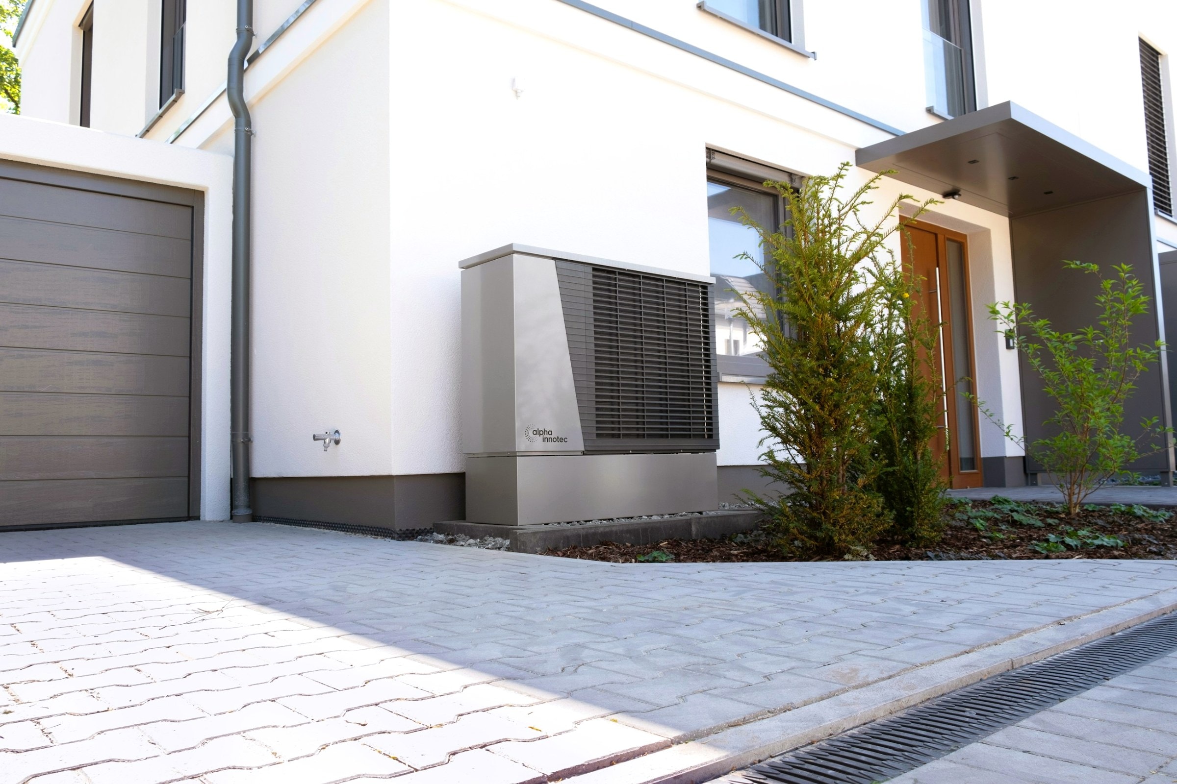 Luft-Wasser-Wärmepumpe vor einem modernen Einfamilienhaus