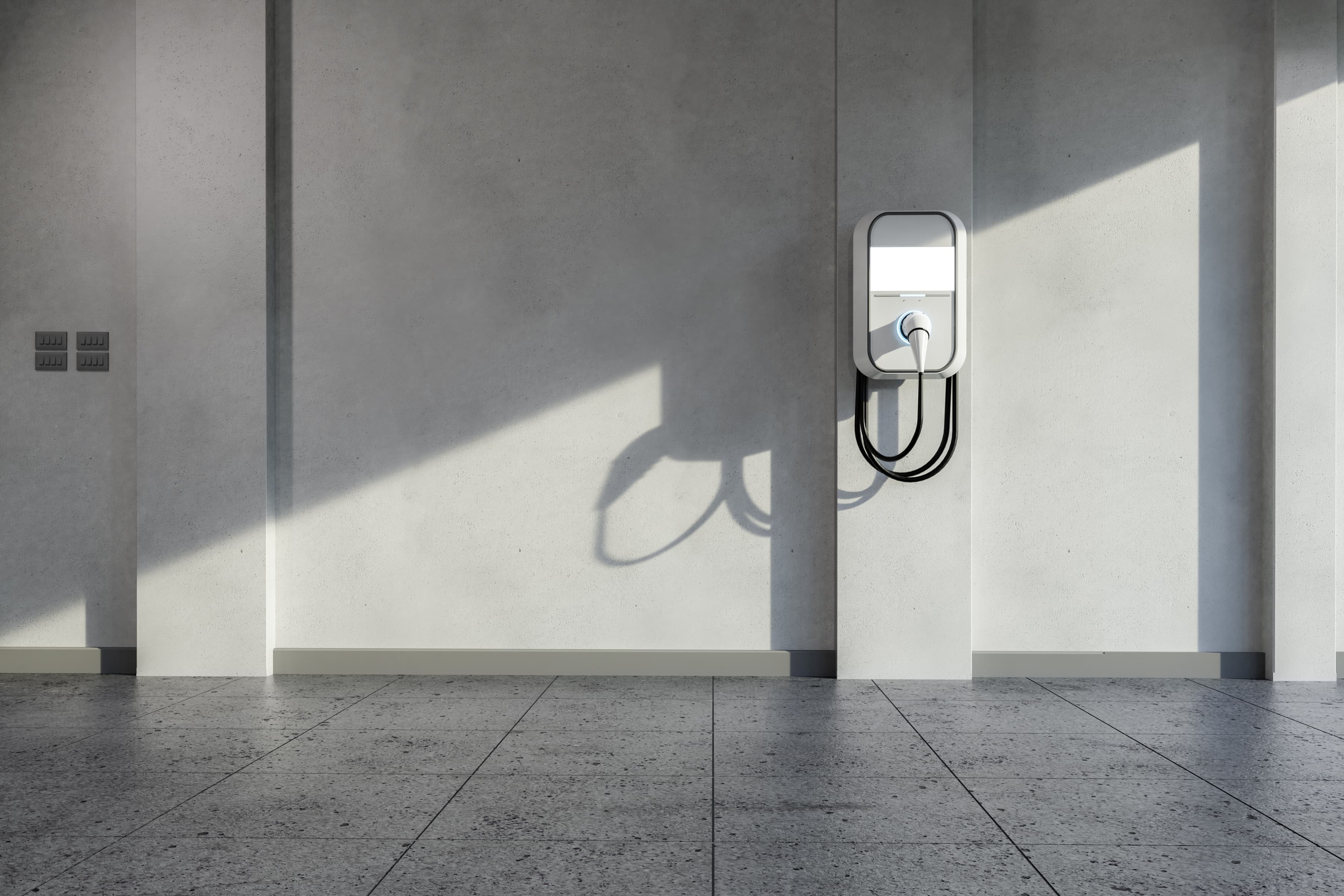 An Betonwand montierte Wallbox mit Ladekabel zum Laden von Elektroautos in der Garage