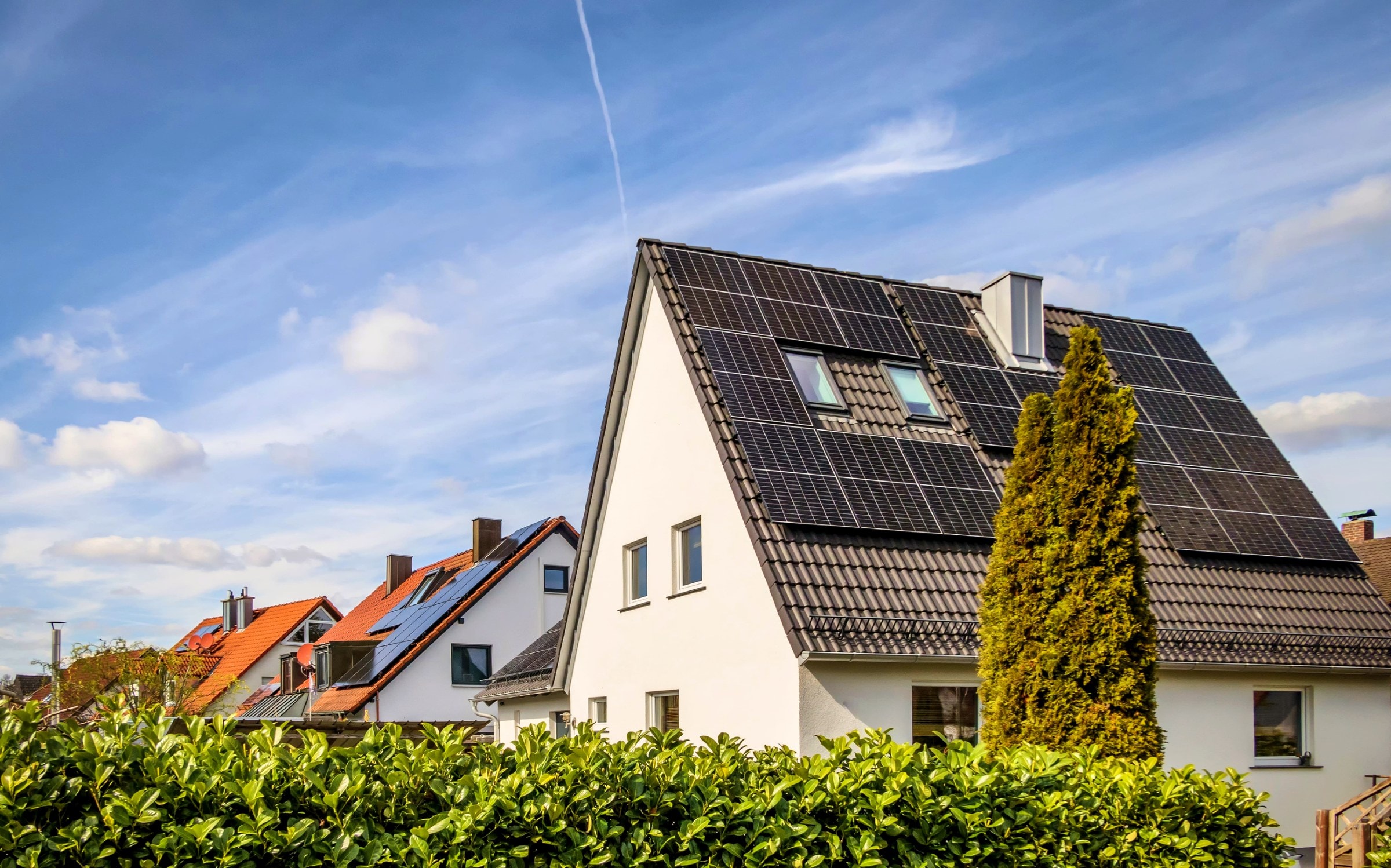 Einfamilienhäuser mit schwarzen Solarmodulen auf dunklen Ziegeldächern