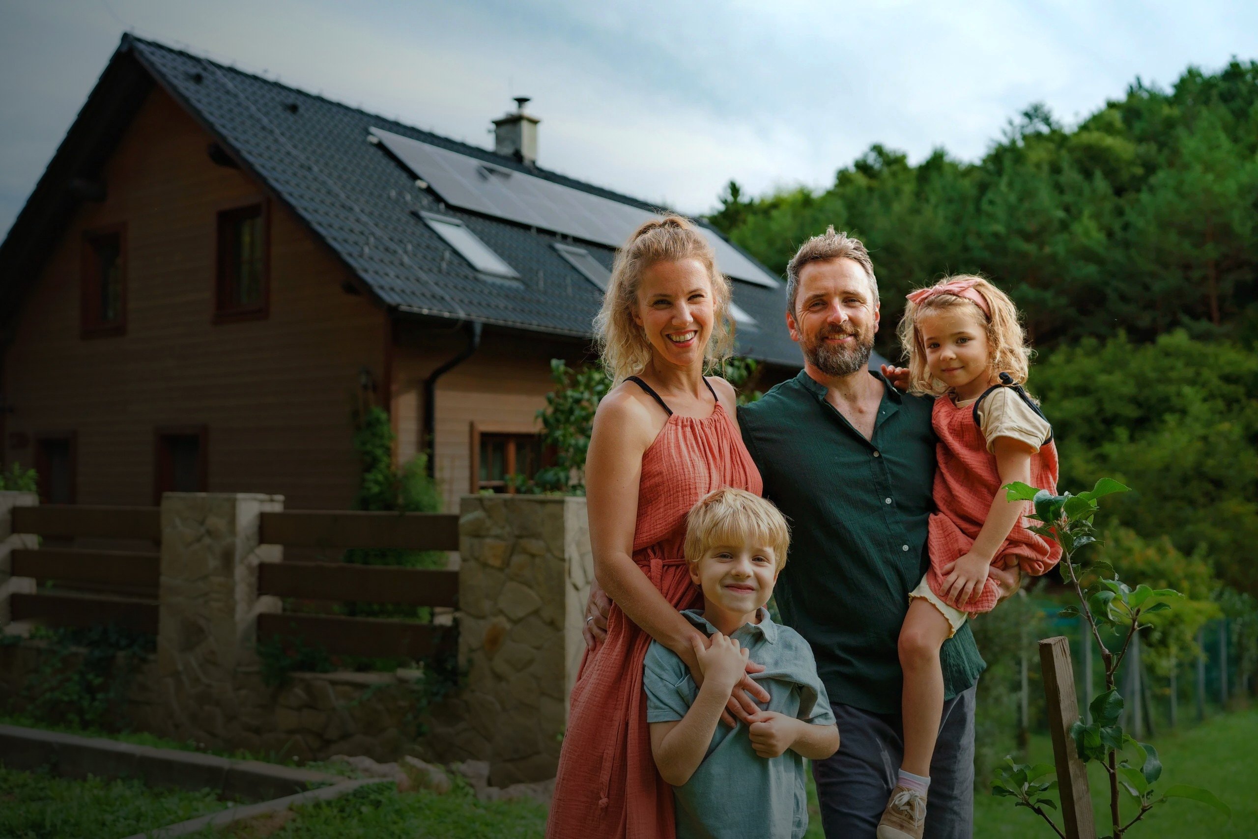 Familie vor ihrem Eigenheim mit Solaranlage in Norddeutschland