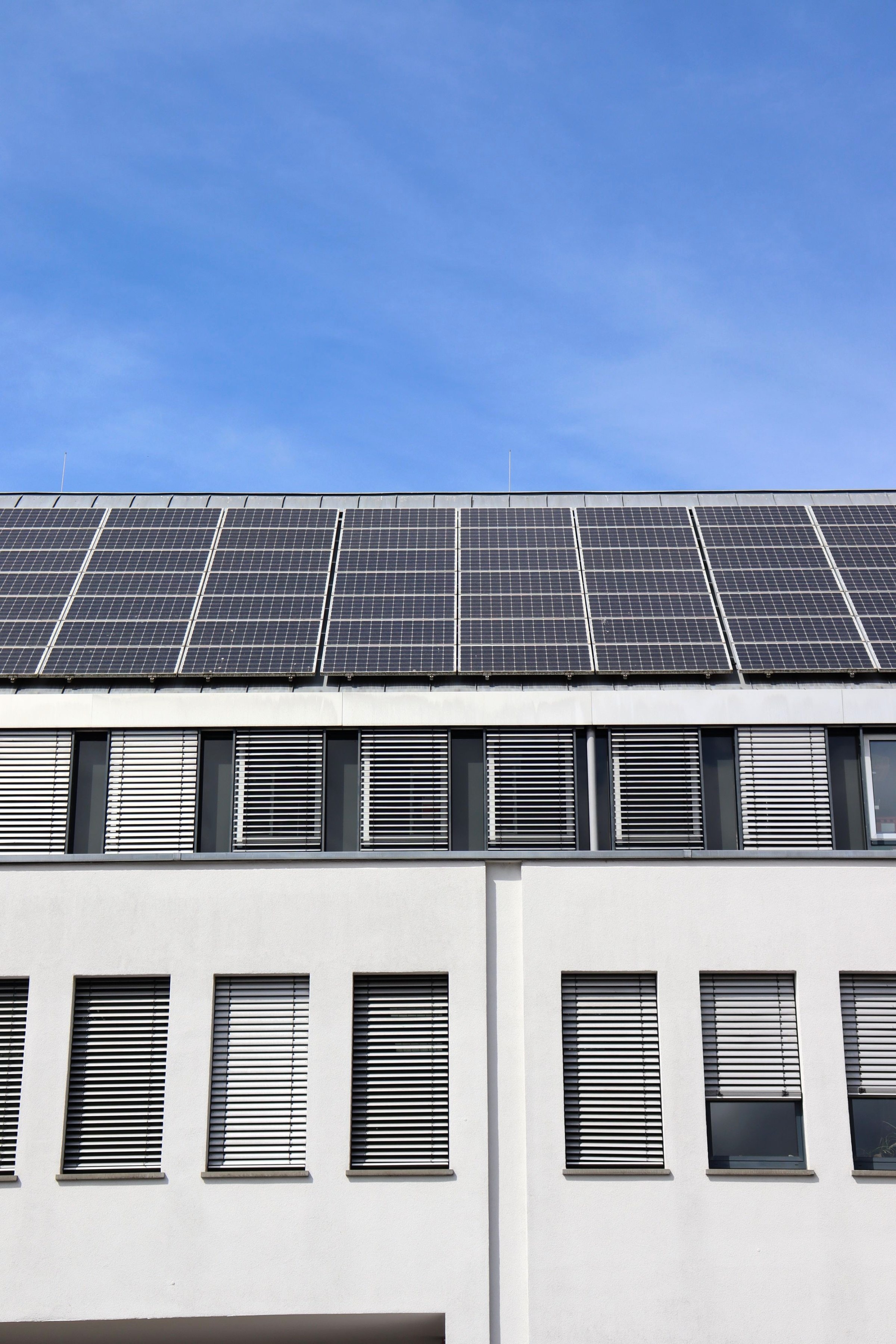 Mehrfamilienhaus mit schwarzen Solarmodulen auf dem Dach