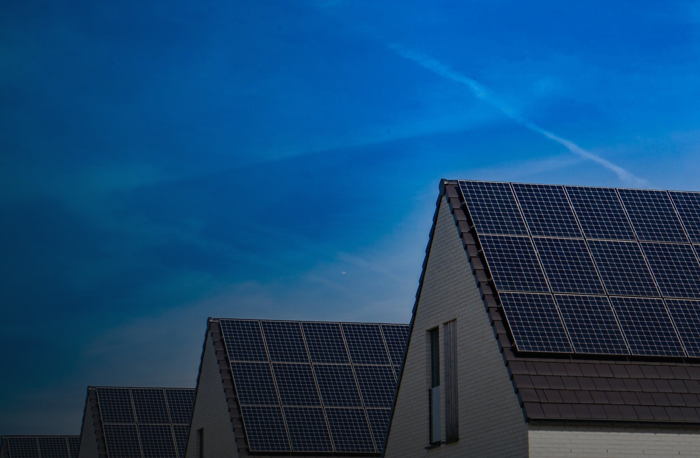Neubauten mit schwarzen Solarmodulen auf den Giebeldächern