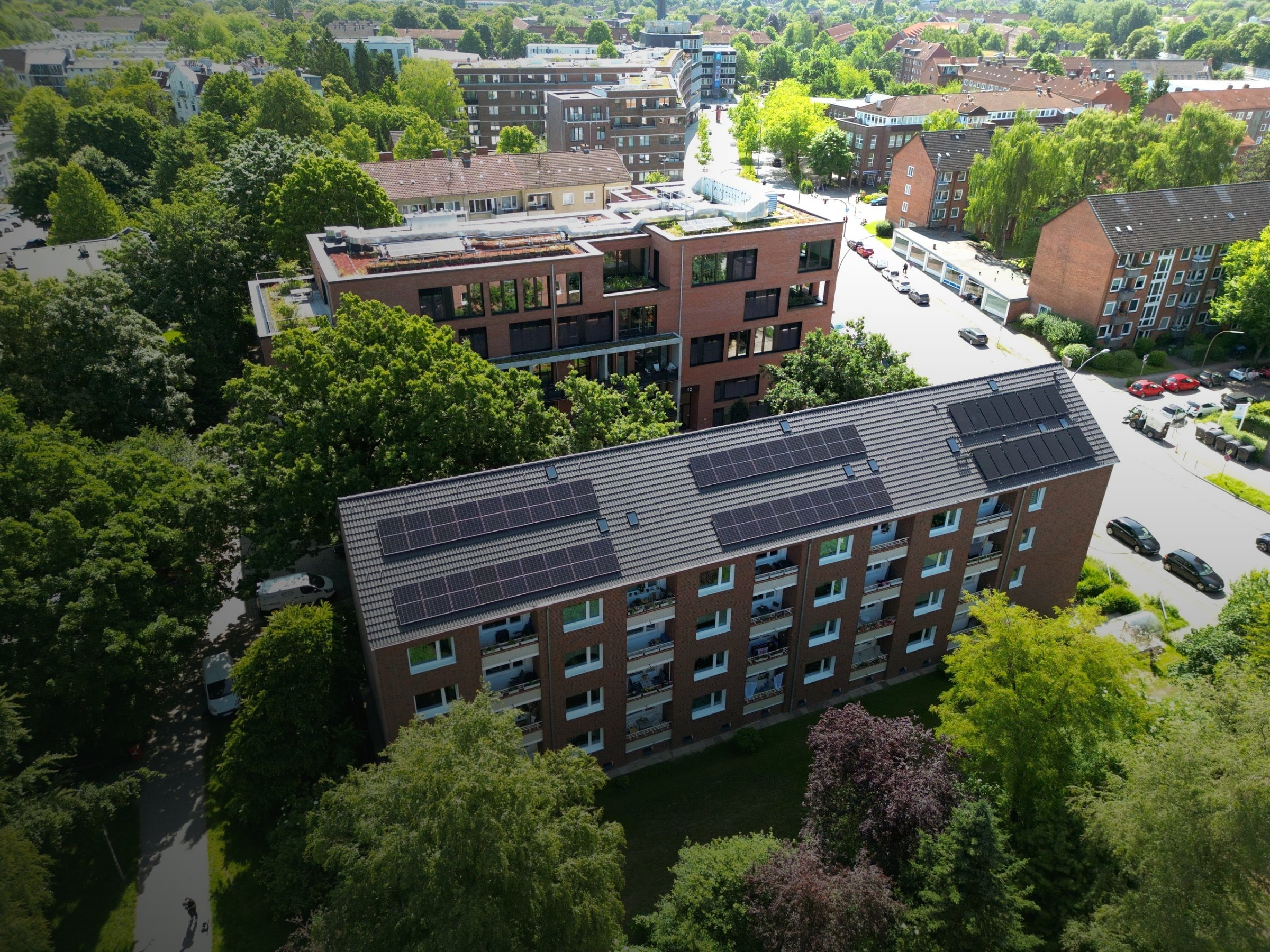Luftaufnahme eines Mehrfamilienhauses mit Photovoltaikanlage auf dem Dach in der Stadt