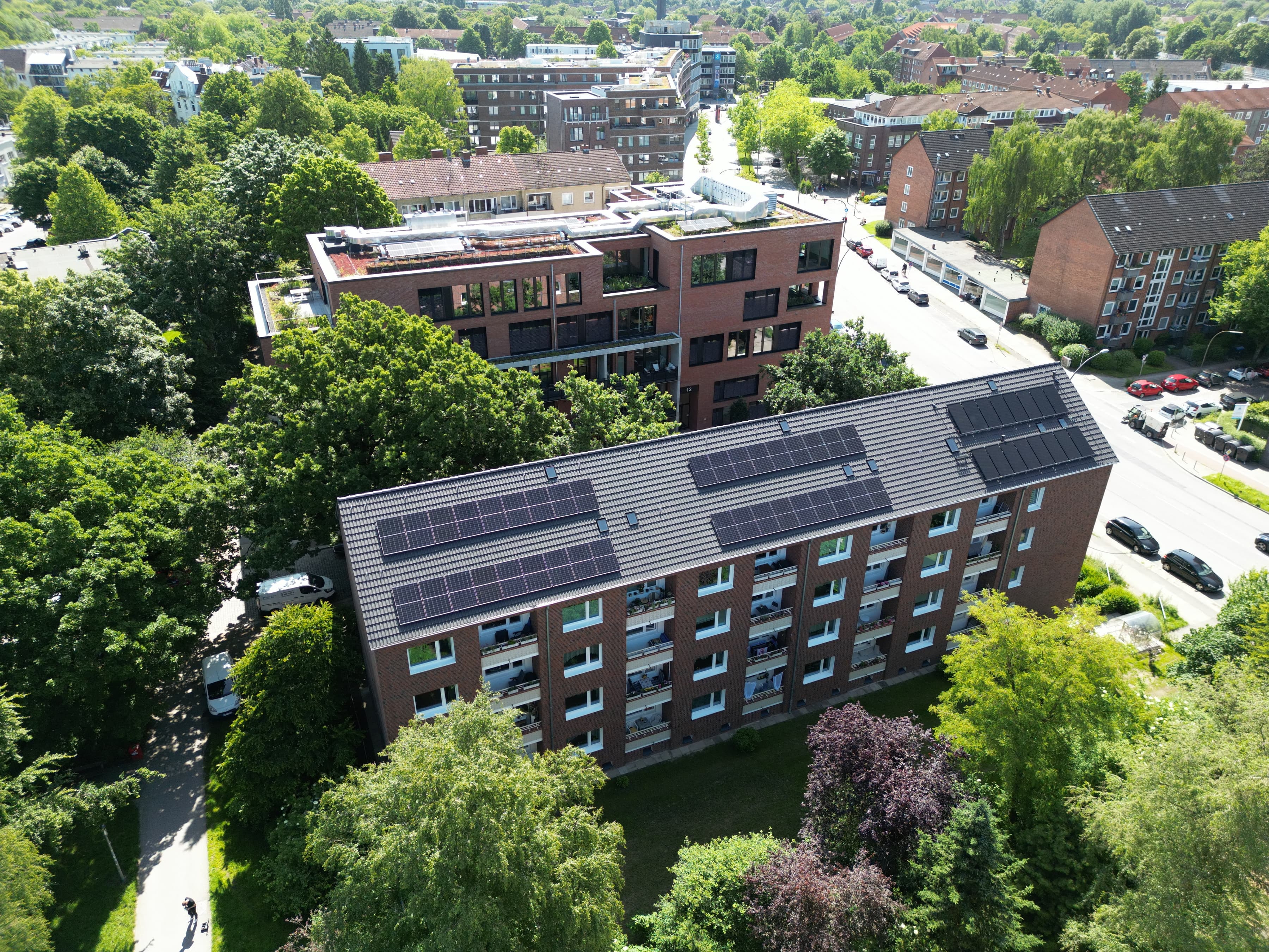 Luftaufnahme eines Mehrfamilienhauses mit Photovoltaikanlage auf dem Dach in der Stadt