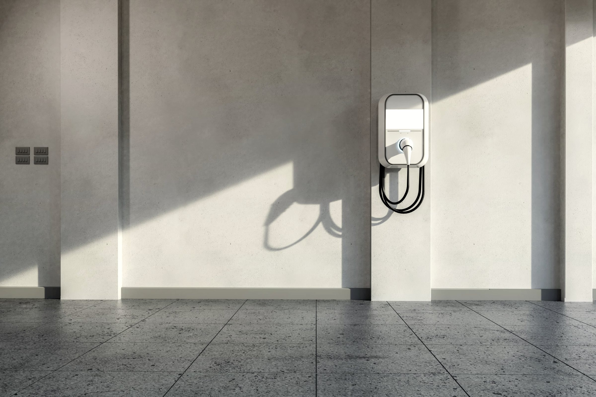 An Betonwand montierte Wallbox mit Ladekabel zum Laden von Elektroautos in der Garage